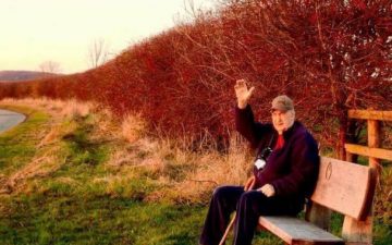 john davison poet sat on a bench waving